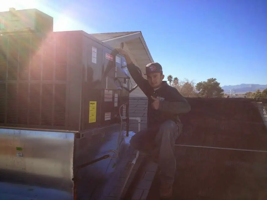 HVAC technician performing Boiler Repair on a rooftop unit in Freeport
